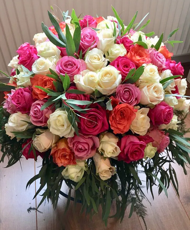 Kleurrijke mix van rozen in rond bloemstuk